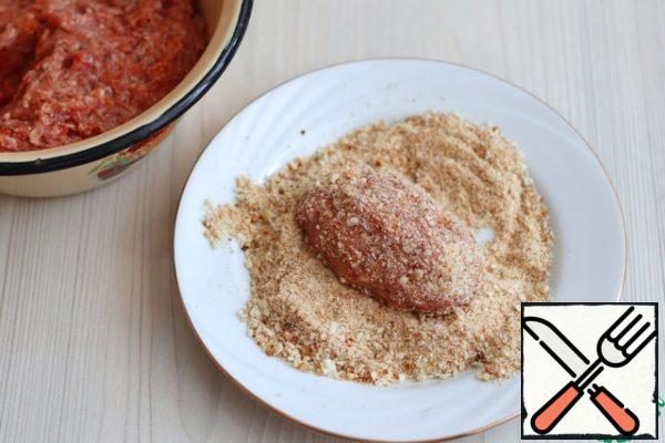From the prepared minced meat, form cutlets, roll them in breadcrumbs.