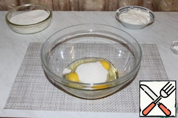 Break the eggs into a Cup and add sugar. Whisk well.