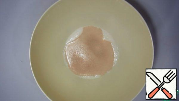 Dissolve the yeast in warm milk, add sugar and a tablespoon of flour. Mix and let stand for 10 minutes until the foam cap appears.