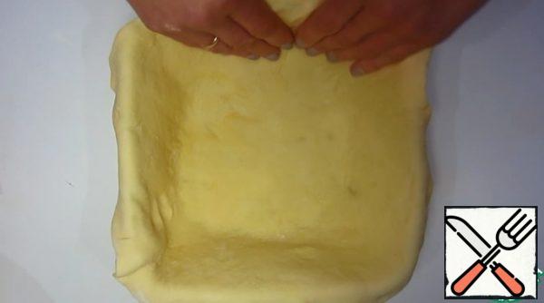 Roll out the dough and put it into a mold, forming the sides.