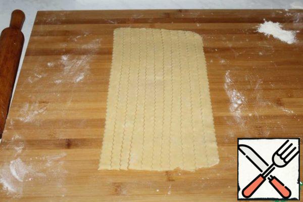 The second piece of dough is rolled out and cut into smooth strips 1 cm thick.