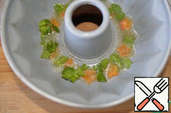 Take the form in which you will prepare the aspic. For a presentable presentation, I took a form with a ring in the middle. Put the carrots on the bottom, parsley leaves on top and pour in a little broth with gelatin, so that in the future the carrots look nice from above. Put it in the refrigerator for 10 minutes to solidify.