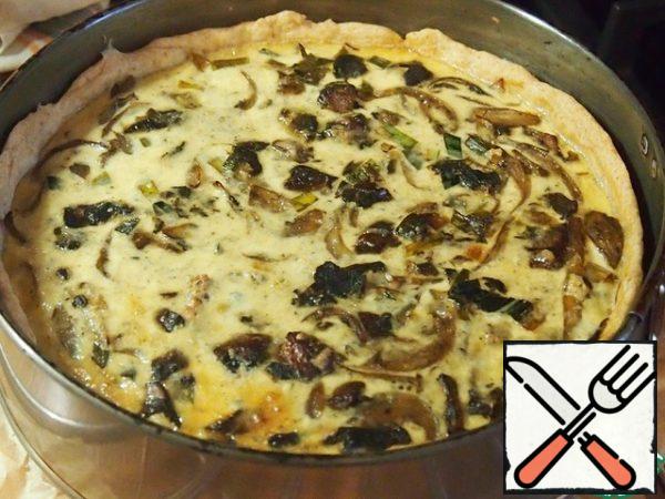 In the form of dough, put the onion and mushrooms and pour the filling.