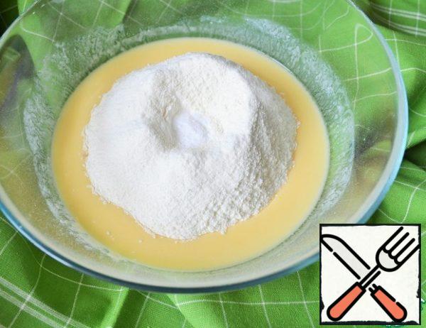 Sift the flour, mix with baking soda, add to the egg-kefir mixture.
Knead until smooth.
