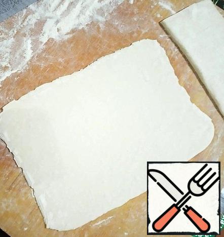 Roll out one half so that it increases in size by 2 times. The thickness of the dough is 2-3 mm.