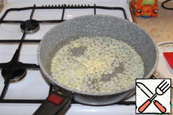Pour 2 tbsp of sunflower oil into the pan. Over low heat, lightly fry the onion and add the garlic.