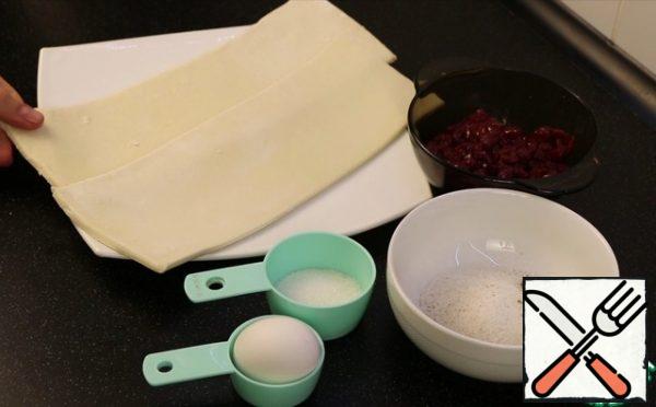The dough is purchased puff yeast.
The filling for bagels is absolutely any, I have canned cherries without pits.
I added sugar for the ears, and cinnamon for the flavor. It will also be very tasty if you add orange or lemon zest.
And, besides, a little more sugar, because cherries are not very sweet.
Yolk for lubrication.