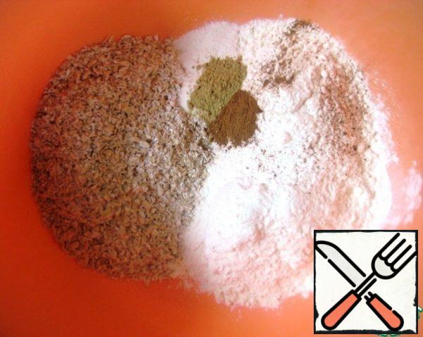 Mix flour, crushed oat flakes, a pinch of salt, baking powder and spices - cinnamon and ginger - in a bowl. Mix it.