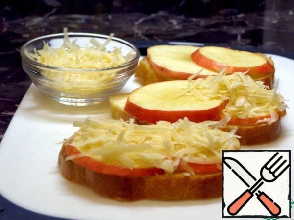 On the bread, put plates of apples, and on them - grated cheese. Fry the sandwiches in a preheated pan, not completely covered with a lid. When the cheese begins to melt, sprinkle the nuts on top.

