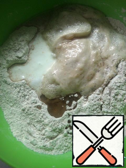 Pour in the yogurt and vegetable oil. Add the yeast mixture. Knead the dough with your hands.
