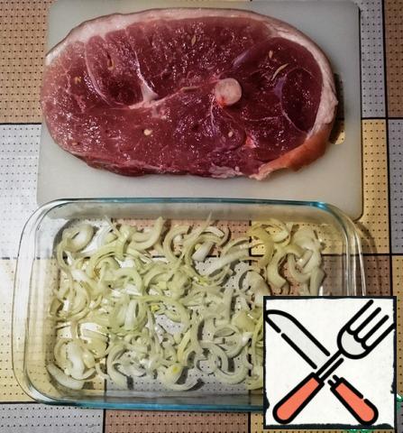 Meat salt, pepper from all sides, who likes-can a little grease the meat with rice vinegar.
At the bottom of the form in which we will bake the meat, put the onion.
