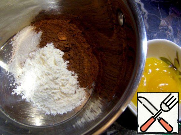 It was the sauce's turn. I was cooking a double portion, so two yolks are visible in the photo. If you have bitter chocolate, add some more sugar. Do not add a lot of flour, the finished sauce should be poured from a spoon, besides, when it cools down, it will thicken even more. In a saucepan with a thick bottom, mix sugar, cocoa and flour, add the yolk and mix well. Pour in the milk and cream, mix again and put on fire. I took the cream not very greasy, and to improve the taste (to make the sauce velvety) I added butter. If you use cream of 30% or more, you don't need to add butter.