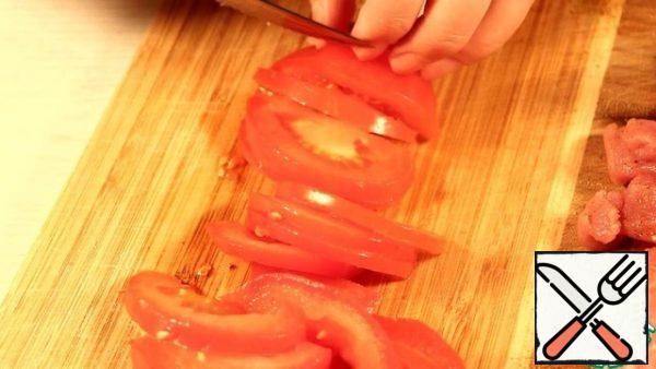 Cut the tomatoes into half rings.