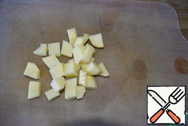 Peel the potatoes, cut them into cubes and put them in the soup. Bring to a boil and cook over medium heat for 10 minutes.