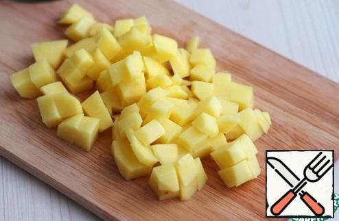 Potatoes (2 PCs.) cut into cubes, lower the potatoes into the chicken broth. Cook the potatoes until Al dente. While the potatoes are cooking, you can start preparing the following ingredients for the soup.