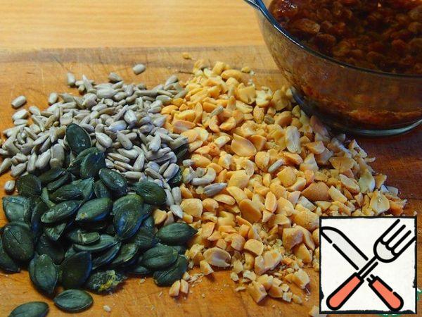 The size of the form is 25 x 35 cm.
The number of nuts, seeds and raisins together - 1 Cup.
Wash the raisins and pour boiling water for a few minutes, then throw them on a sieve.
Nuts (walnuts or peanuts), coarsely chop with a knife, add the seeds.
Then mix it all together.