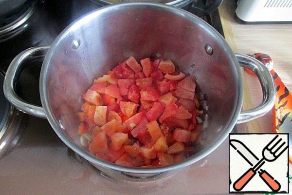 Add garlic and fry for another 1 minute; add carrots and sweet peppers, fry for 1 minute, add tomatoes, cover the pan with a lid and simmer the vegetables for 5 minutes.