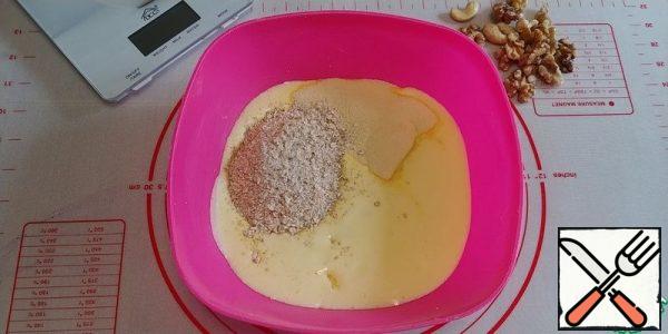 Beat the eggs with sugar into a fluffy foam. The photo is lost).
Add vegetable oil and milk, then semolina and crushed oat flakes, mix.