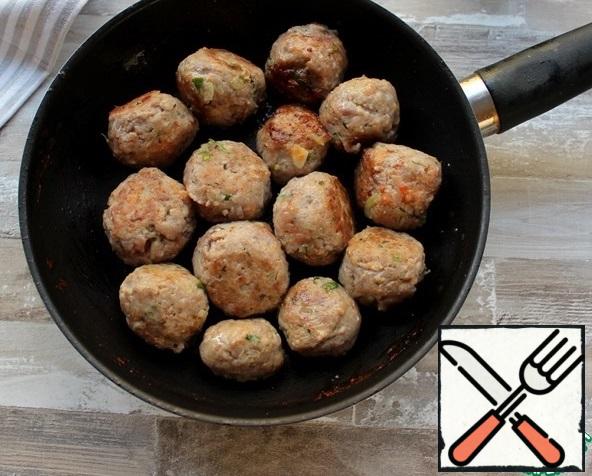 Take the meatballs out of the refrigerator and fry them in a pan in the heated olive oil to brown the balls.