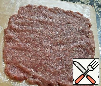 On a cellophane bag, form a rectangle from 1/6 of the minced meat.
