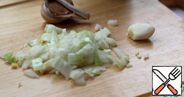 Chop the onion and mince the garlic. Heat the vegetable oil in a thick-walled pan and fry it.