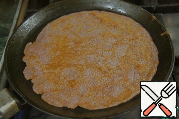 As soon as the color of the dough changes and bubbles appear, turn the pancake over and bake until ready.