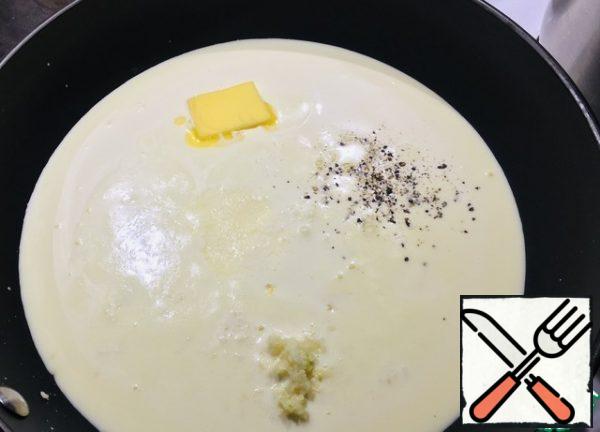 Heat the cream on the stove, add salt, black pepper, 3 cloves of garlic to squeeze through a garlic press, add 1 tablespoon of corn starch, butter, Parmesan cheese, mix everything well.