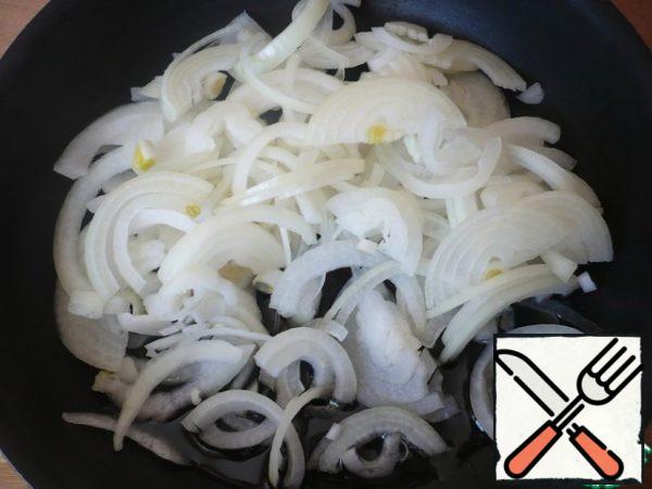 Peel the onion and cut it into half rings. In a deep frying pan, heat the vegetable oil. Fry the onion until Golden.
