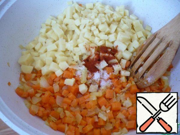 Add potatoes cut into small cubes to the vegetables, salt to taste, add sweet paprika. Put the potatoes out with the onions and carrots, about 5 minutes.