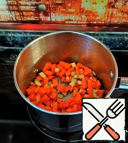 Then add diced celery and finely chopped garlic. Mix everything, reduce the heat, cover and cook for 15-20 minutes until the carrots soften.