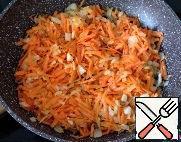 Peel the carrots, wash them, and grate them on a coarse grater. Add to the onion and fry for another minute over medium heat.