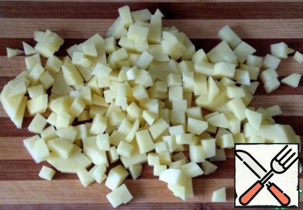 Peel the potatoes, wash them, and cut them into cubes.