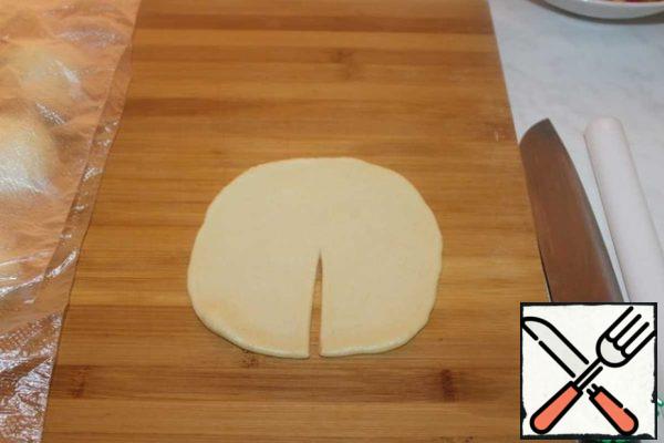 Roll out a piece of dough in a circle 3-4 mm thick and make an incision.