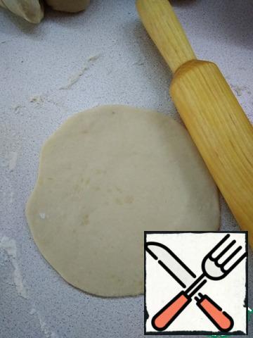 After an hour, knead the dough and divide into 8 parts (about 80 g).
On a floured surface, roll out one piece of dough into a circle about 15 cm in diameter.