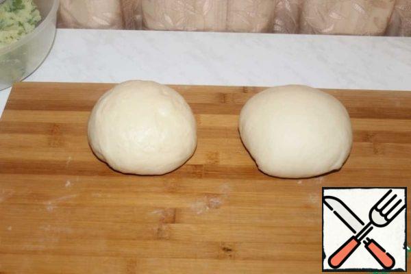 Divide the dough into 2 parts. We roll up each piece. We give you 10 minutes to rest.