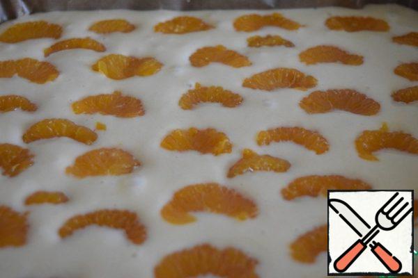 Cover the form with baking paper or oil.
Pour the dough on a baking sheet and flatten.
Put the tangerine slices on the dough, slightly "drowning" them in the dough.
Place in a preheated oven ( 190-200 degrees) for 25-30 minutes. We are guided by our oven, checking readiness with a match (toothpick).