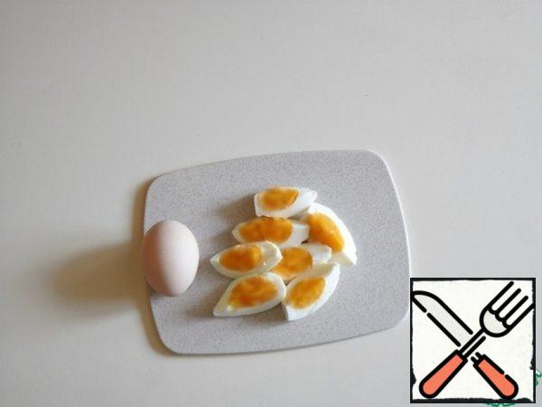 that is, the yolk is no longer liquid, but also not dry.
Cool, peel and cut lengthwise into four parts.