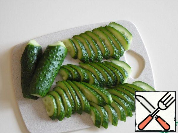 Cucumbers cut into half rings with a thickness of 3-4 mm.