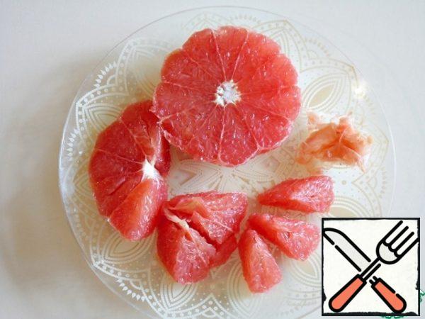 She peeled the grapefruit, cut it in half, and cut the partition near the center to remove the pulp. In this way, a clean flesh without veins and webs was obtained.