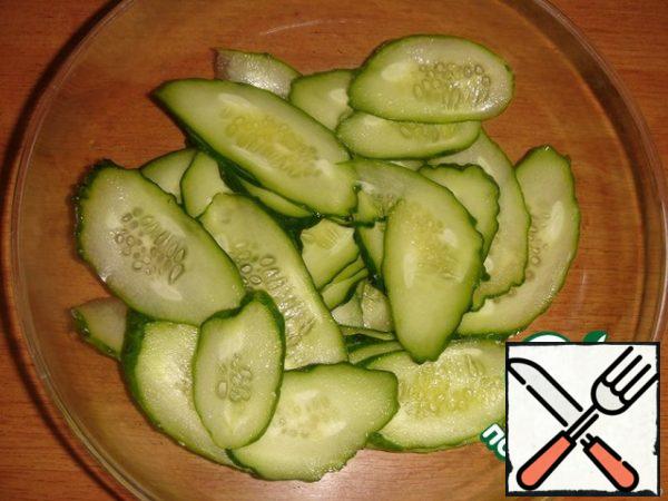 Cut the cucumber into thin slices diagonally. If cucumbers are small, then you can cut thin layers along.