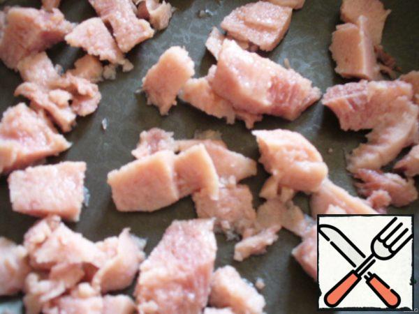 Cut the ham into small pieces and fry it in a preheated pan.