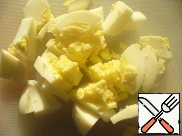 Boil the egg and cut it into large pieces.
