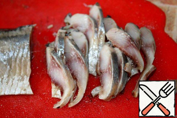 Clean the herring from the bones and divide into pieces.