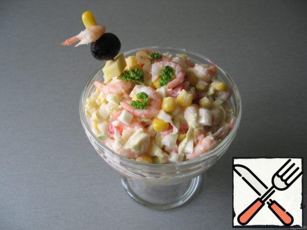 We fill the salad with mayonnaise and serve it garnished with herbs and shrimp.