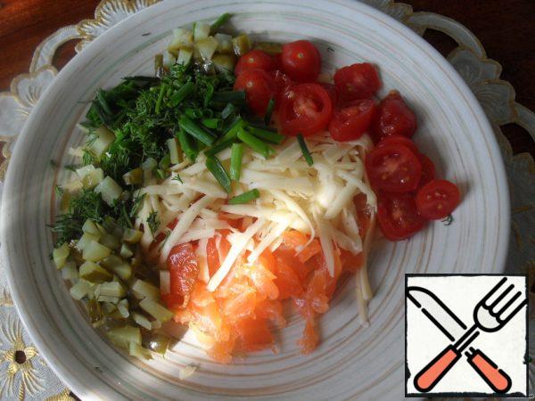 Cut the salmon into small pieces.
Grate the cheese on a large grater.
Tomatoes cut into circles, gherkin cubes, add chopped greens.