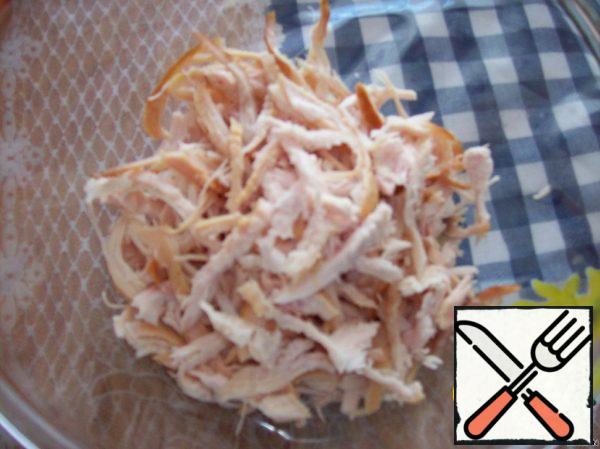 Peel the chicken breast and slice the chicken with your hands (you can also slice it, but I prefer to rip).