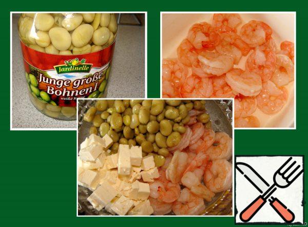 Drain the liquid from the beans,
sprinkle the thawed shrimp with lemon juice and salt,
cut the cheese into cubes.