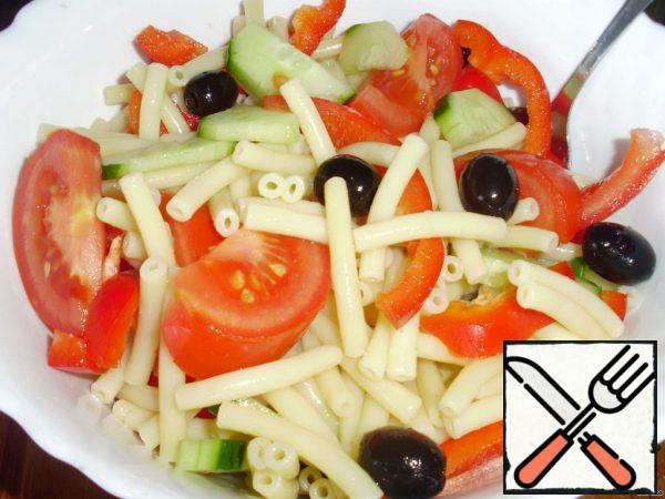 Mix the finished noodles, paprika, tomatoes, cucumber and olives.