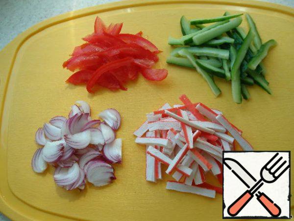 Cut the crab sticks, onion, and cucumber and tomato into strips, first freeing them from the seeds.