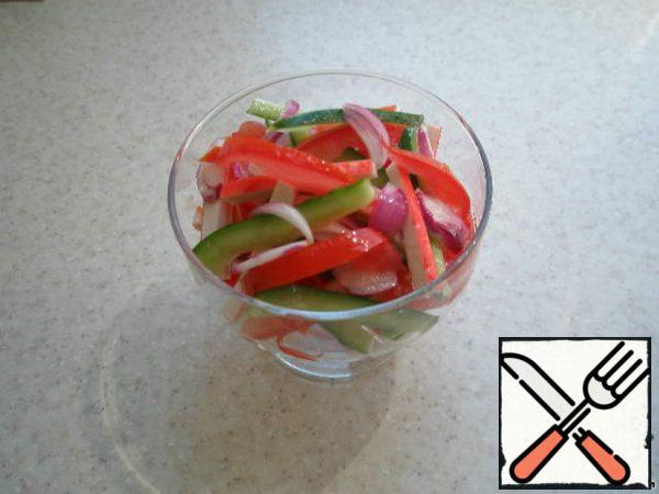 At the end of the time, add to the pickled crab sticks and onions, cucumber and tomato. Carefully mix everything and put it in the crematorium.
